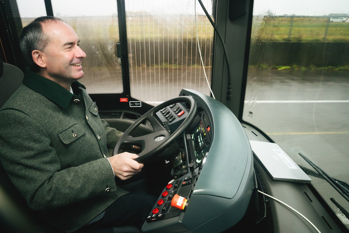 Staatsminister Aiwanger sitzt im Cockpit des Buses hintern Steuer