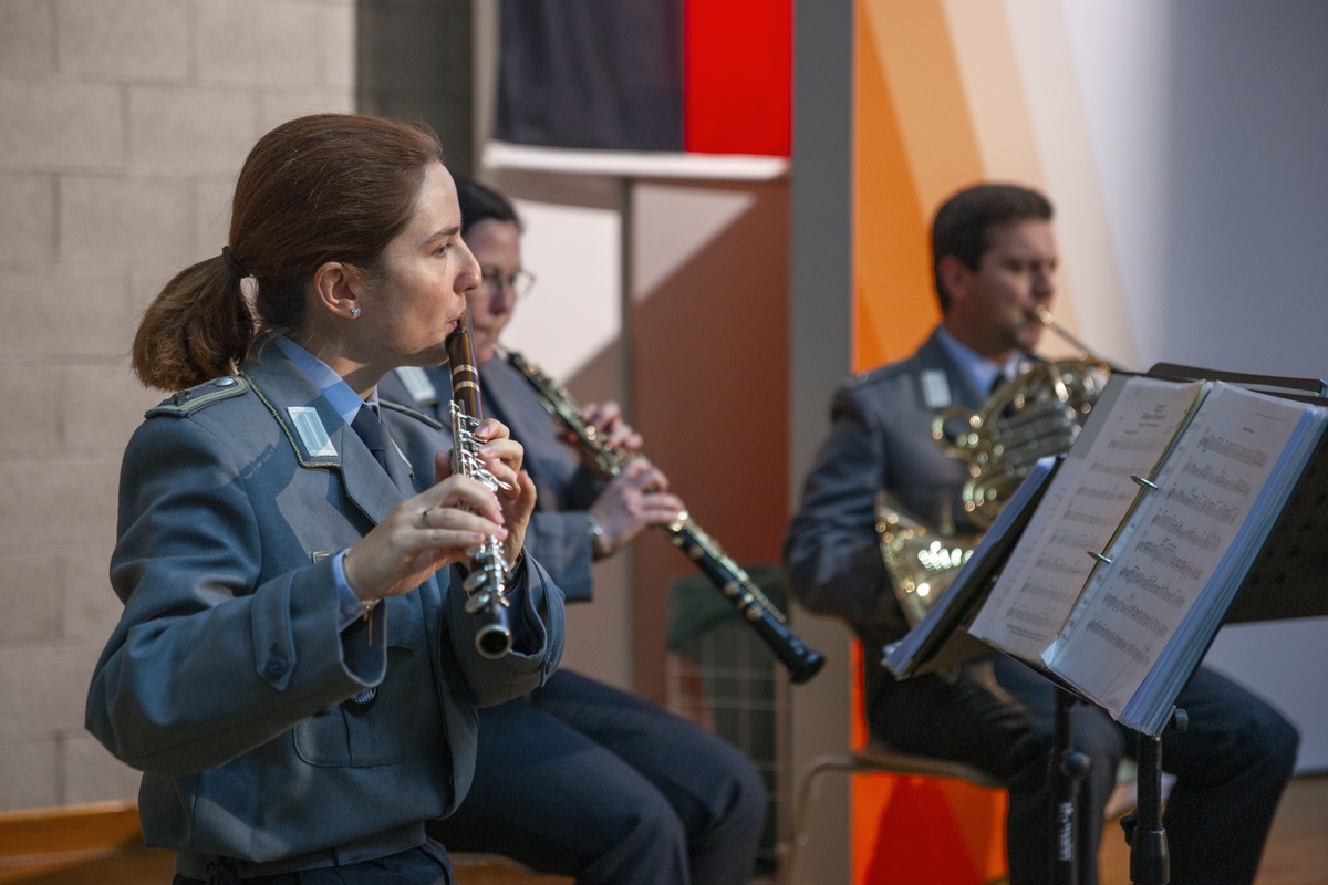 Das Gebirgsmusikkorps der Bundeswehr beim Dies academicus 2026 Im Vordergrund spielt eine Soldatin im Festanzug eine Querflöte. Im Hintergrund sind weitere Musikanten mit ihren Instrumenten.