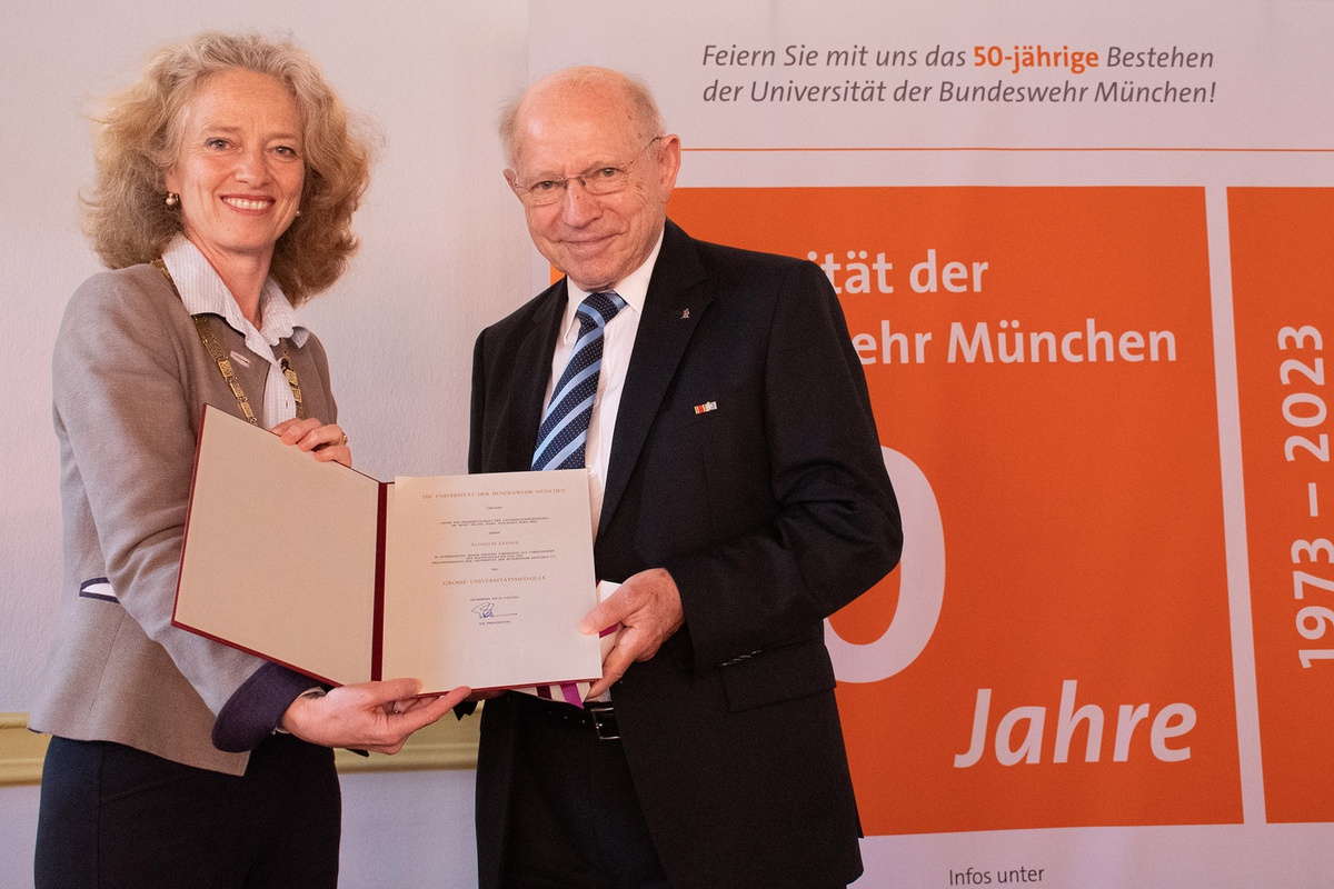 Links im Bild: Präsidentin Prof. Eva-Maria Kern, rechts im Bild Alfred H. Lehner. Beide halten gemeinsam ein Schriftstück lächelnd in die Kamera.